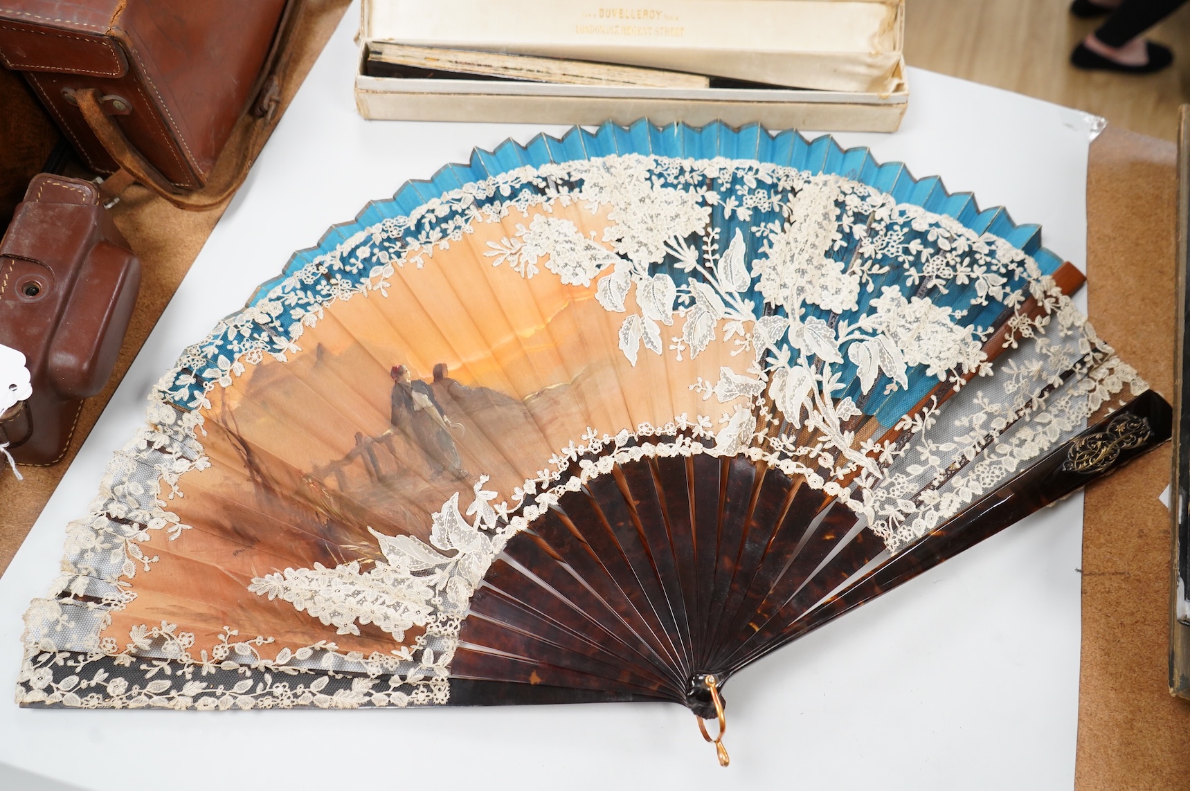 A gold mounted lace and hand painted fan and three others to include a lacquered example, one cased